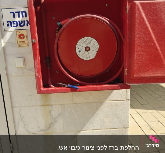 גלגלון כיבוי אש בקיר חיצוני עם שלט
